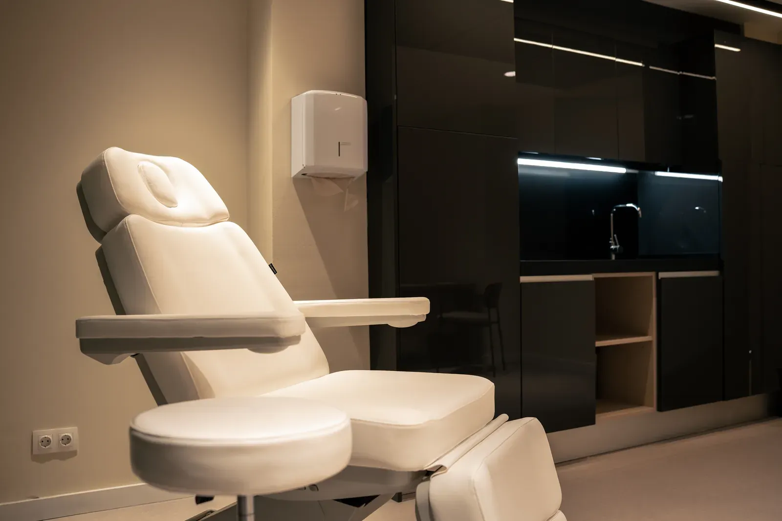 Sillón de exploración en una sala de la consulta, con mobiliario claro y luz cálida