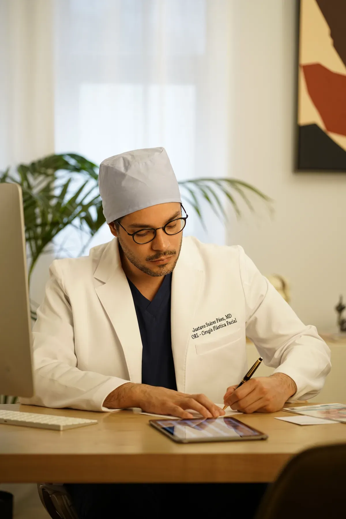 El Dr. Gustavo Suárez trabaja con una tableta en su despacho de la consulta