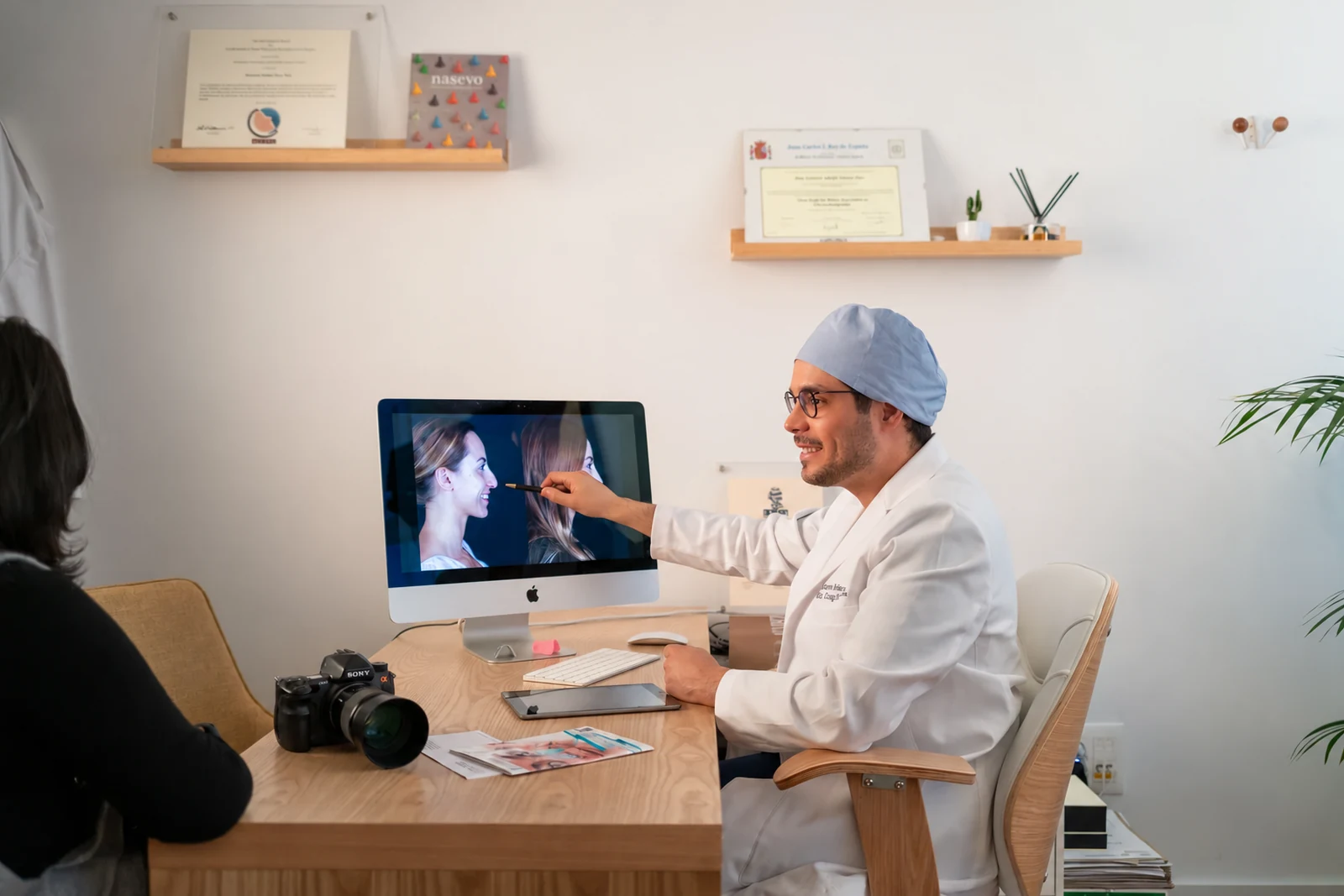 Dr. Gustavo Suárez pointing at a simulation on the screen in his studio, with the camera on the desk